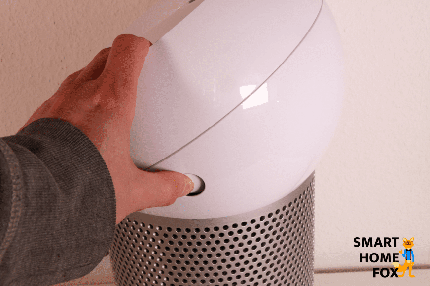 Um den oberen Teil des Dyson Pure Cool Me BP01 Luftreinigers abzunehmen, muss man die seitlichen Knöpfe eindrücken